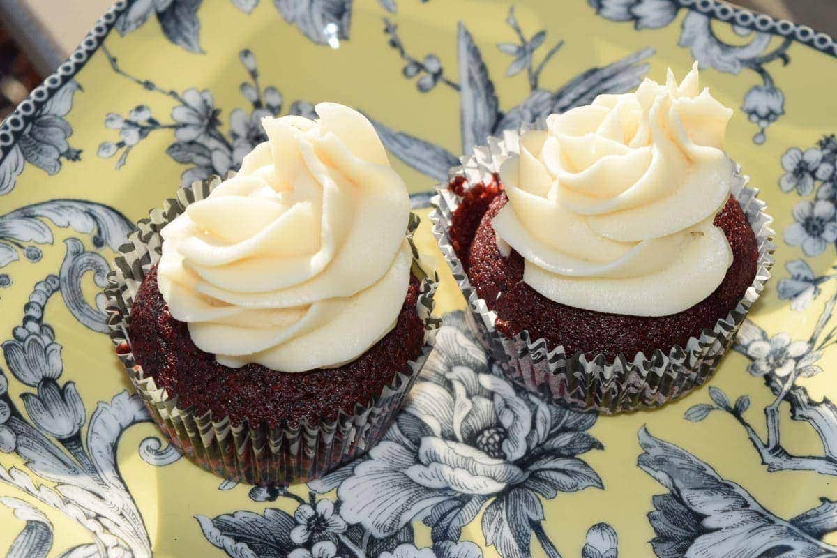 two homemade red velvet cupcakes with cream cheese frosting