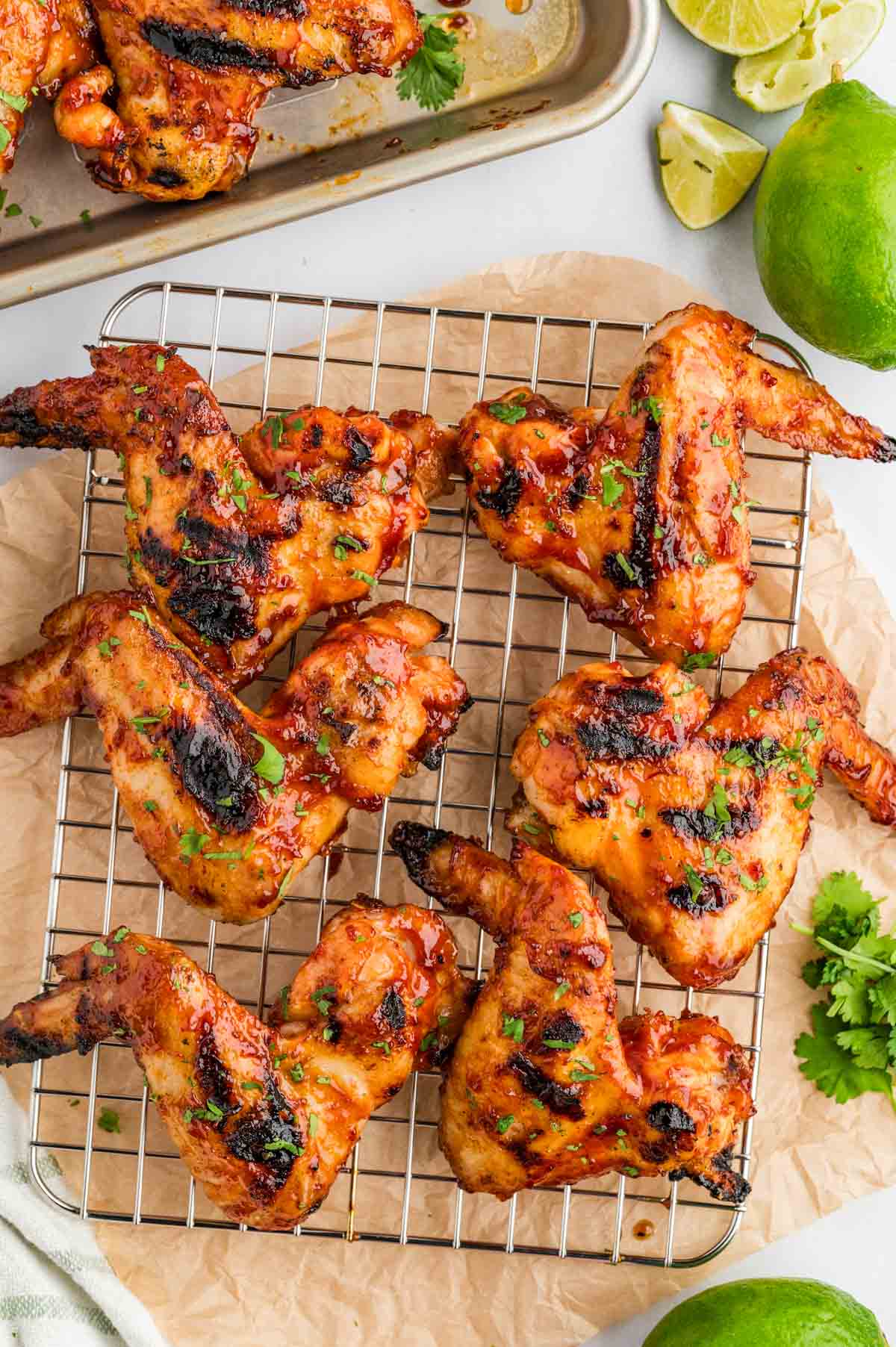 Honey Chipotle BBQ Chicken wings on a baking rack with parchment paper underneath.