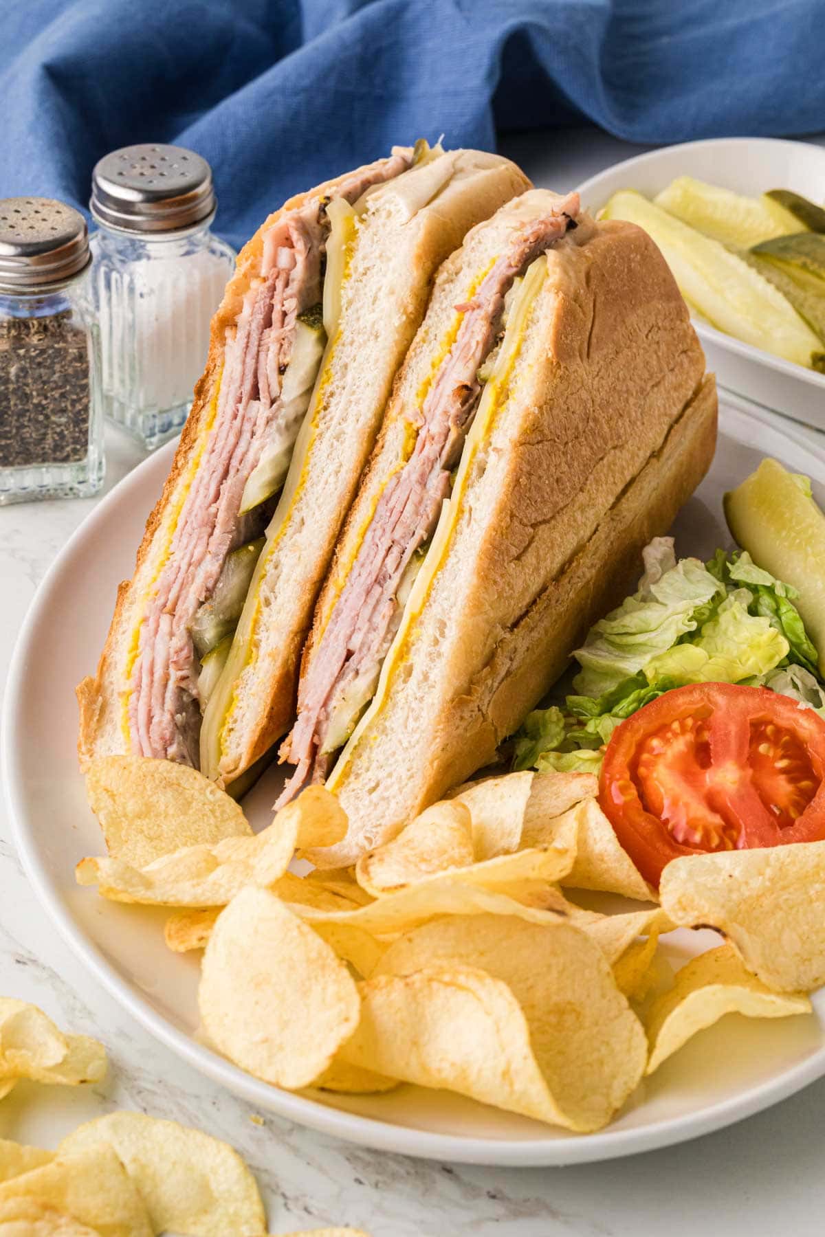 A sandwich on a plate with chips.