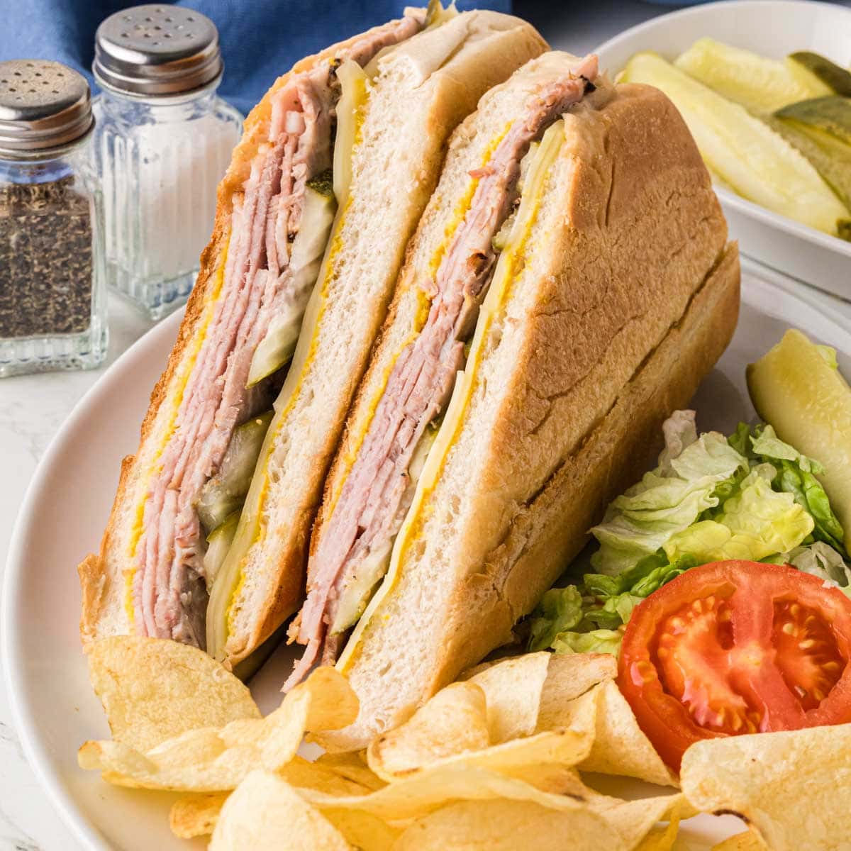 A sandwich on a plate with chips.