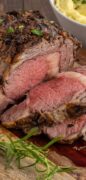 A prime rib roast is sliced to reveal the perfectly cooked and juicy inside in this image only pin.