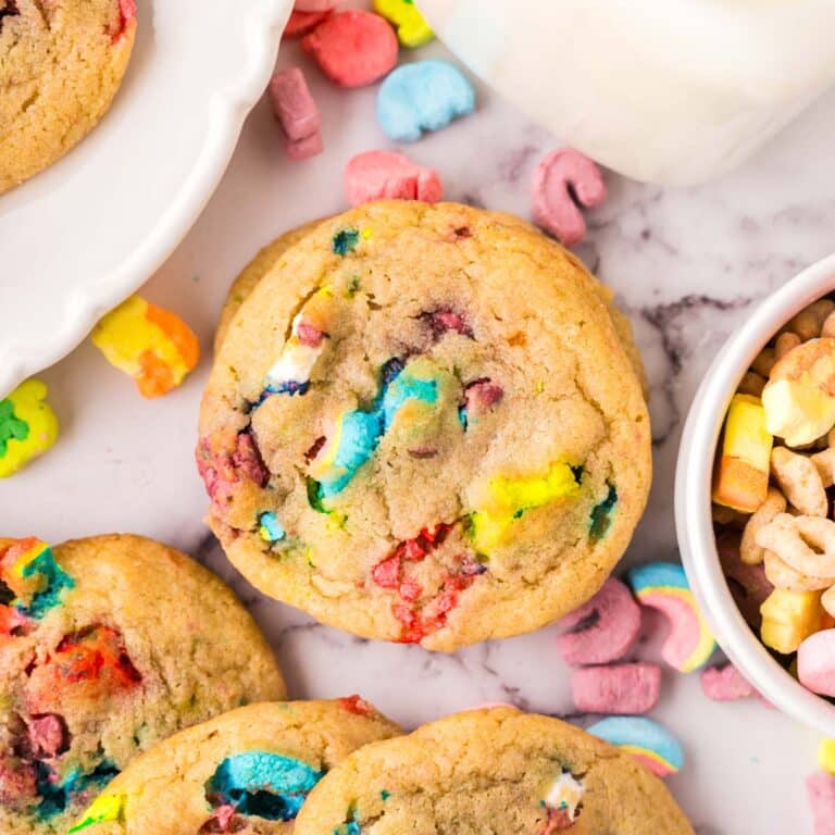 Lucky charms cookies with cereal marshmallows scattered around them.