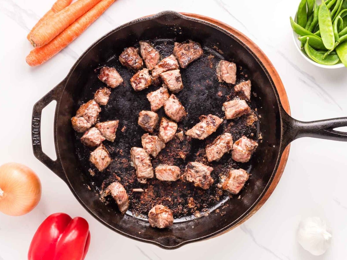 Cooked steak bites in a cast iron skillet.