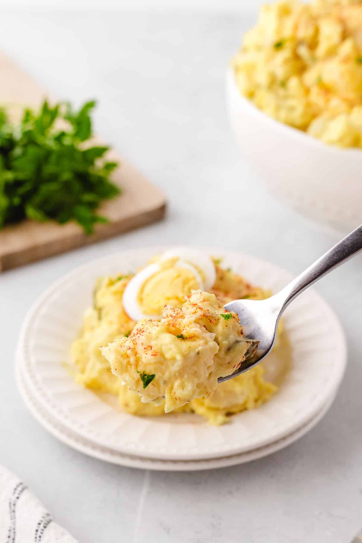 A fork picking up a bit of potato salad.