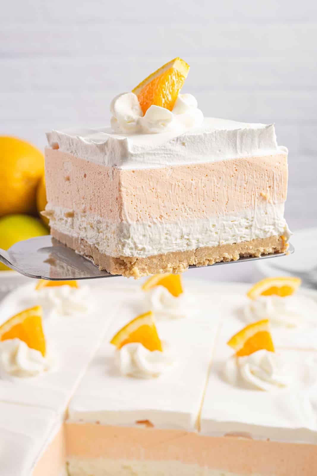 A serving spatula removing a slice of orange dreamsicle bar.