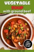 An overhead shot of a bowl of vegetable soup with ground beef is featured in this graphic image.