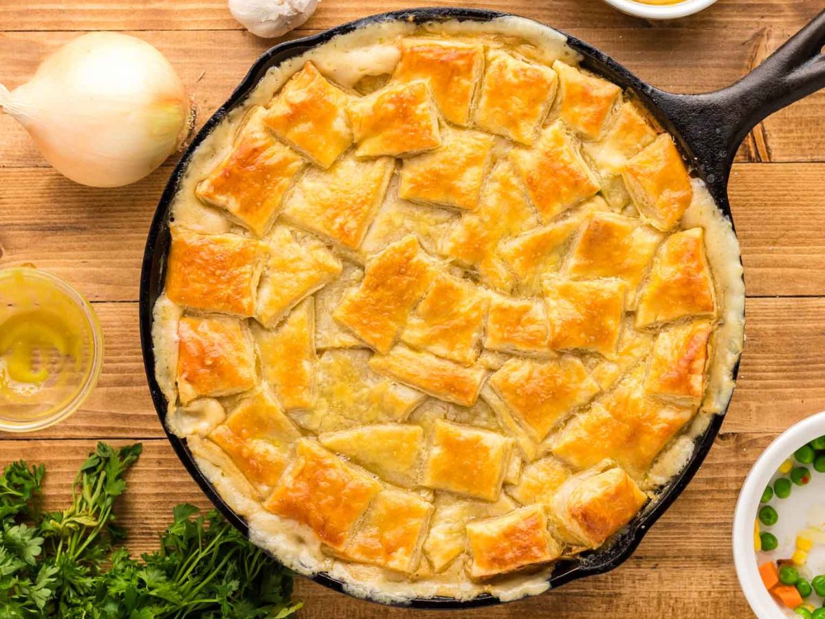 A puff pastry chicken pot pie cooked in a cast iron skillet fresh out of the oven.