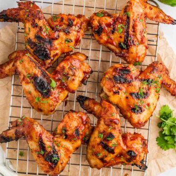 Honey Chipotle BBQ Chicken wings on a baking rack with parchment paper underneath.