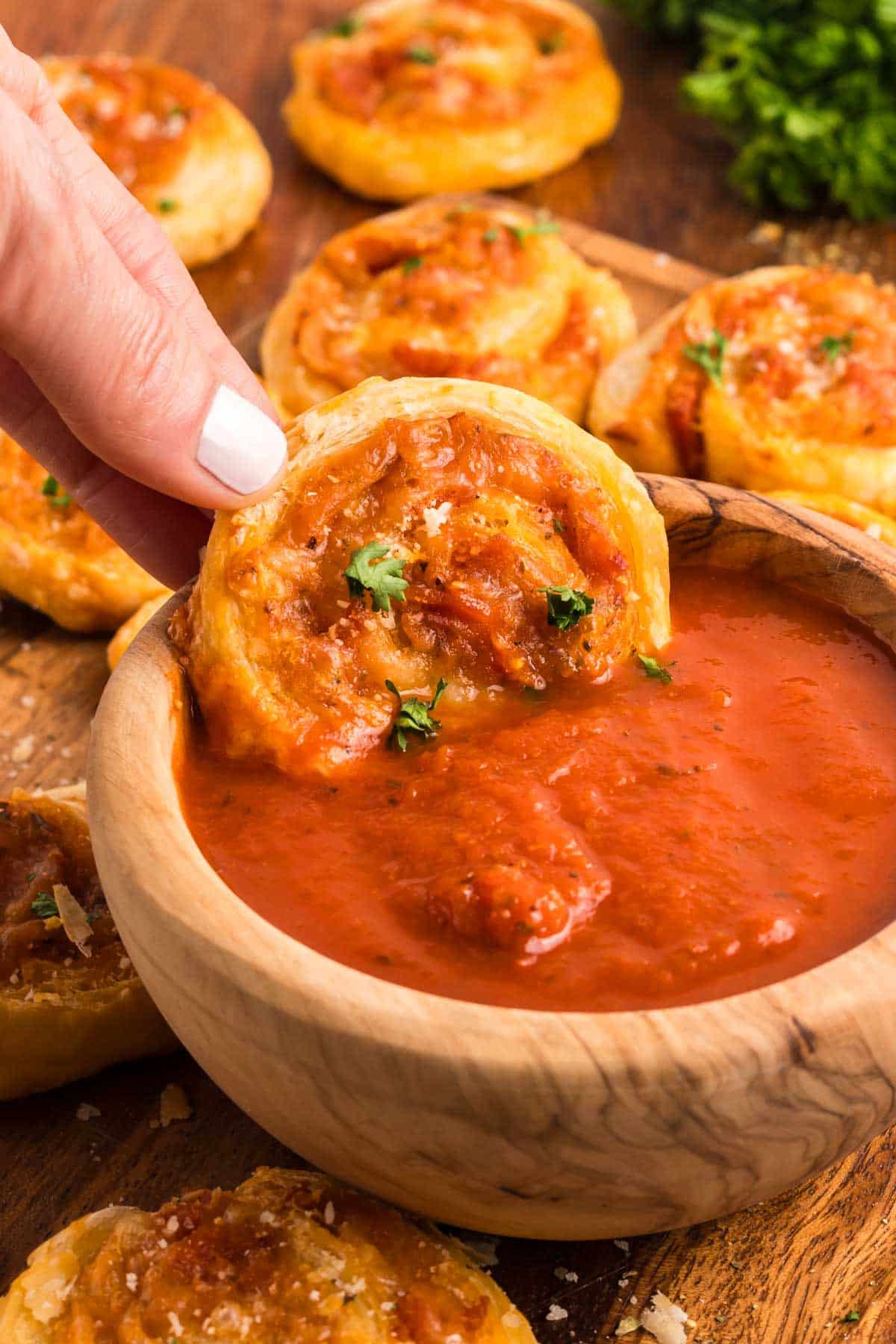 Dipping a pepperoni pinwheel into marinara sauce.