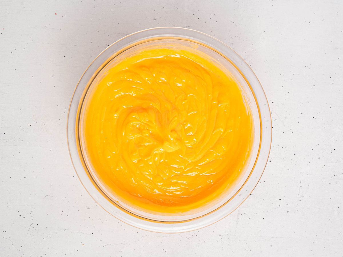 Vanilla pudding mixed with orange food coloring in a bowl. 