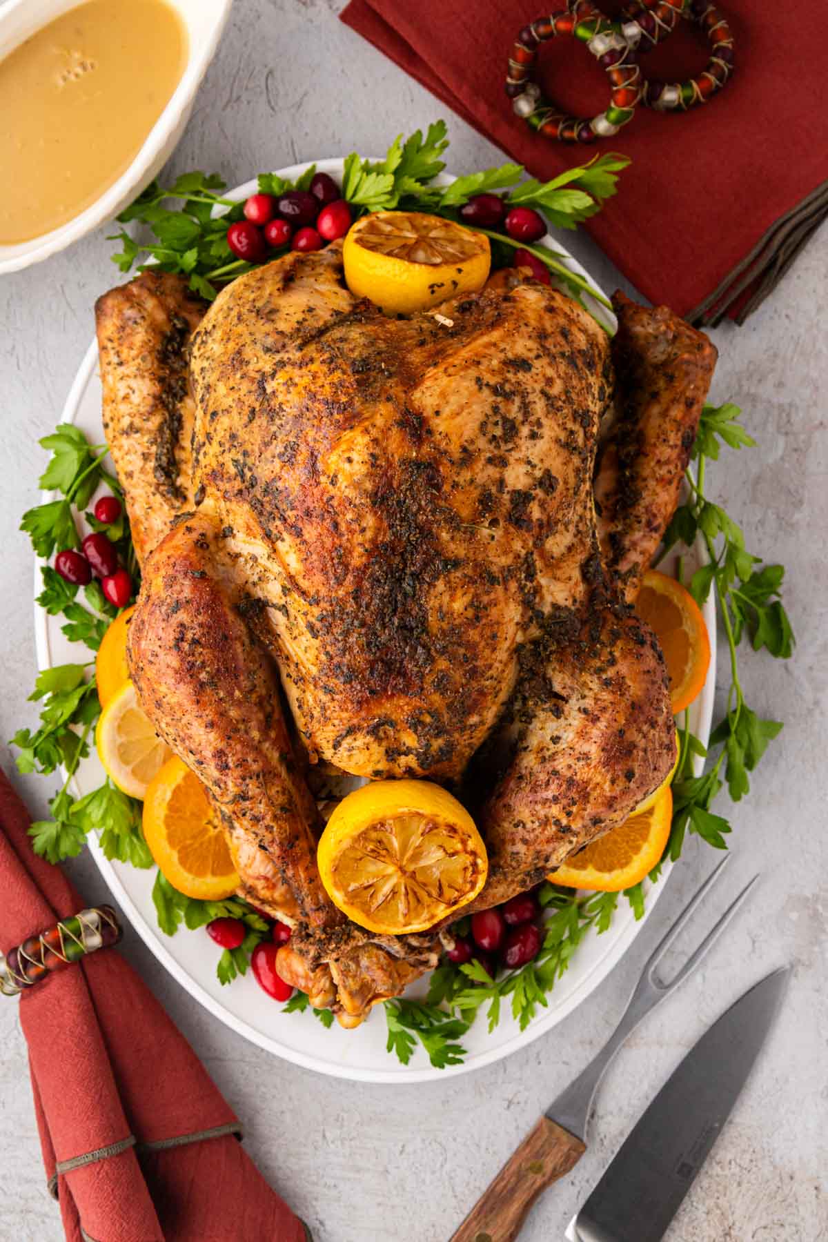 An overhead view of the roasted turkey on a white serving platter.