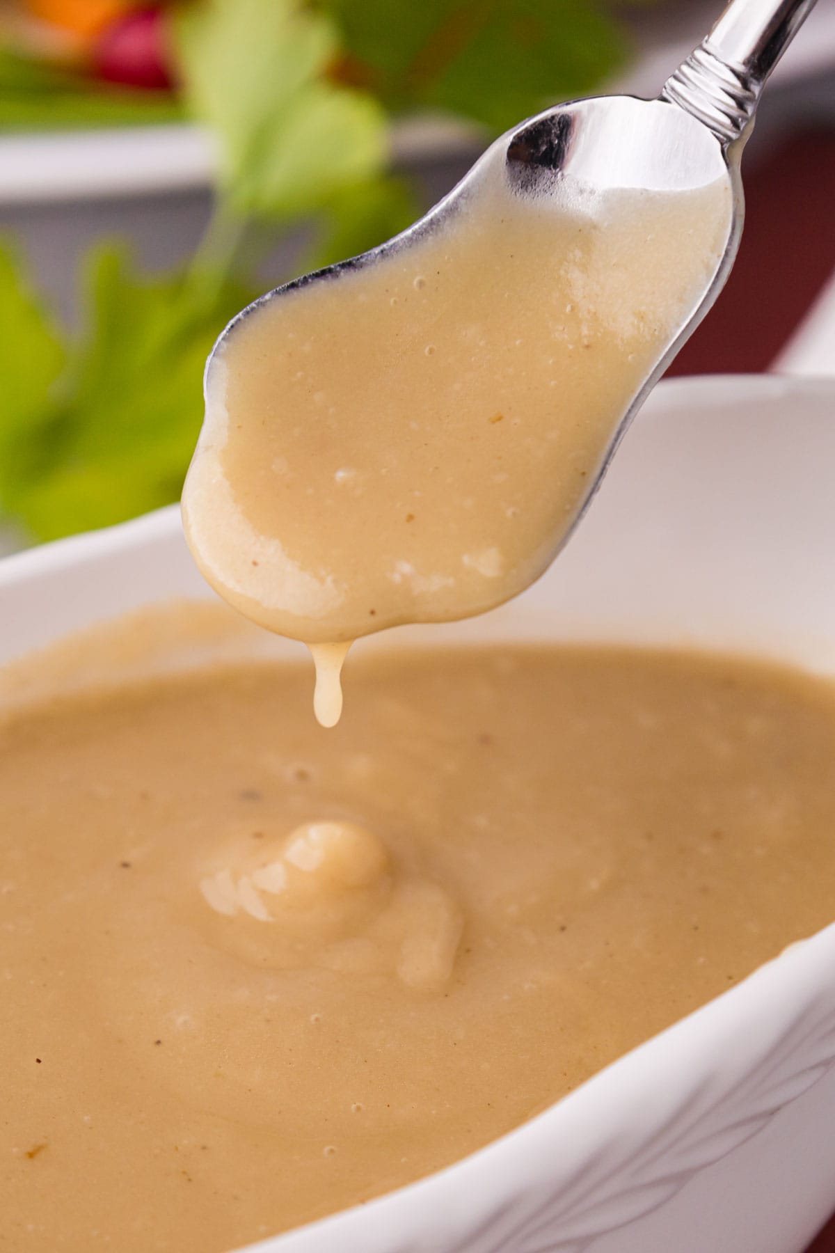 A serving spoon remove gravy from a bowl