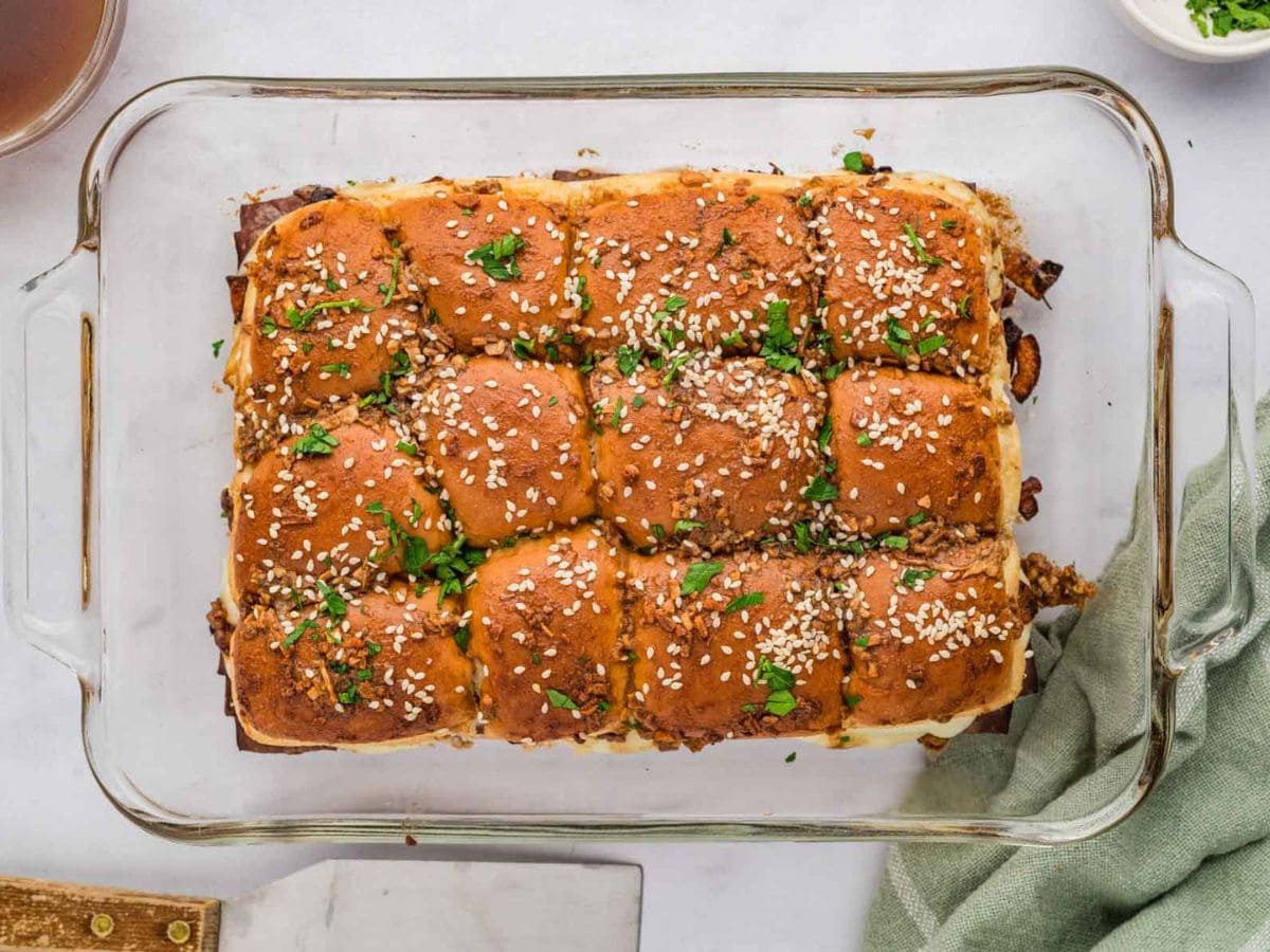 Overhead shot of French dip sliders in a glass baking dish.