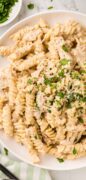 Pinterest image showing a bowl of garlic parmesan chicken with parsley sprinkled on top.