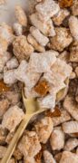 Biscoff Muddy Buddies recipe image close-up with a wooden spoon digging in.