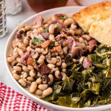 A plate of Black Eyed Peas served with collard greens and cornbread.