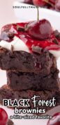 These two Black Forest Brownies are shown stacked and topped with whipped cream and cherries.