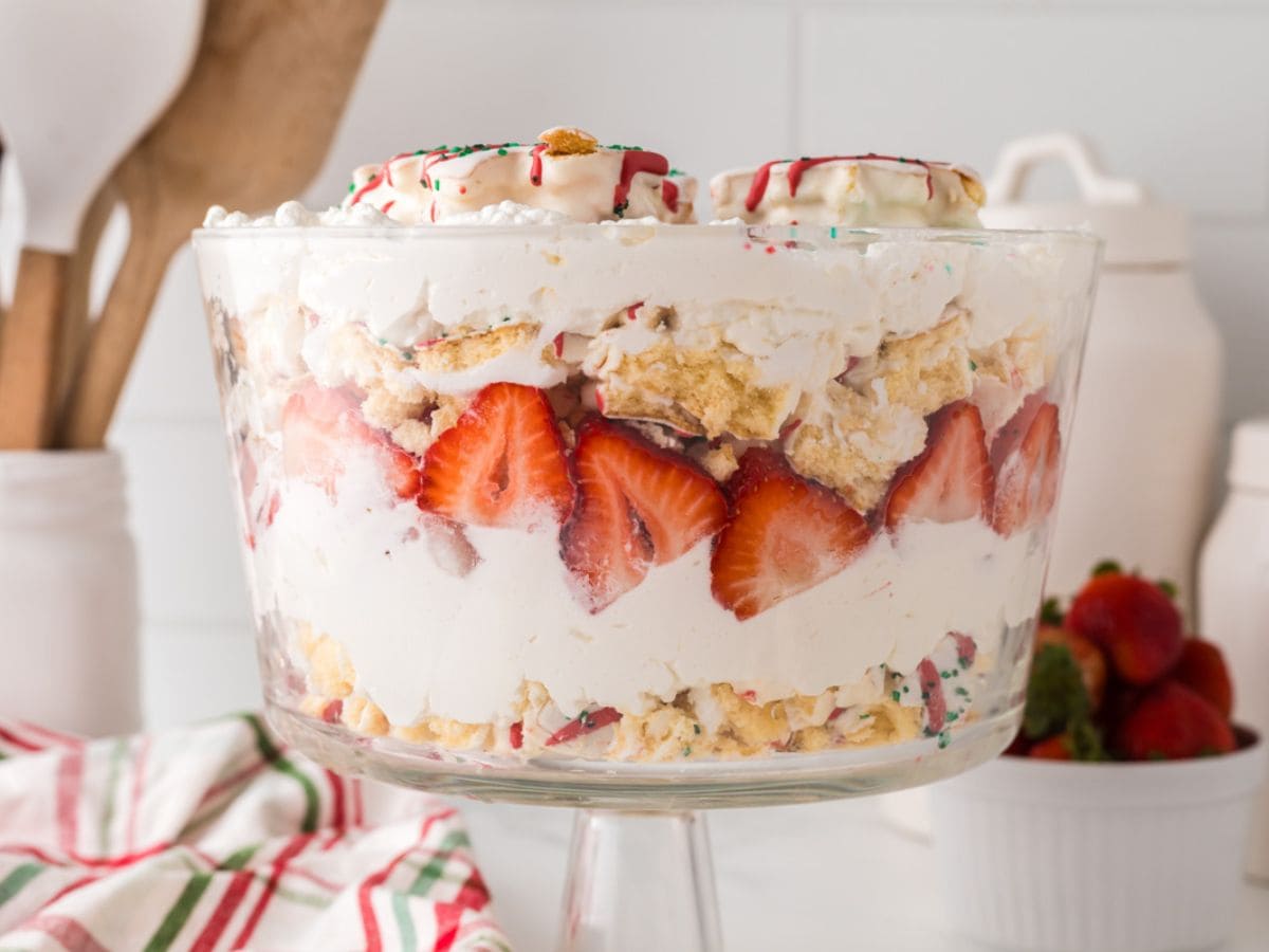 Last trifle bowl filled with layers of Little Debbie Christmas tree snack cakes, whipped cream, and strawberries.