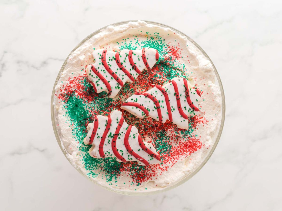 Three Little Debbie Christmas tree snack cakes, and red and green sprinkles on top of the trifle dessert.