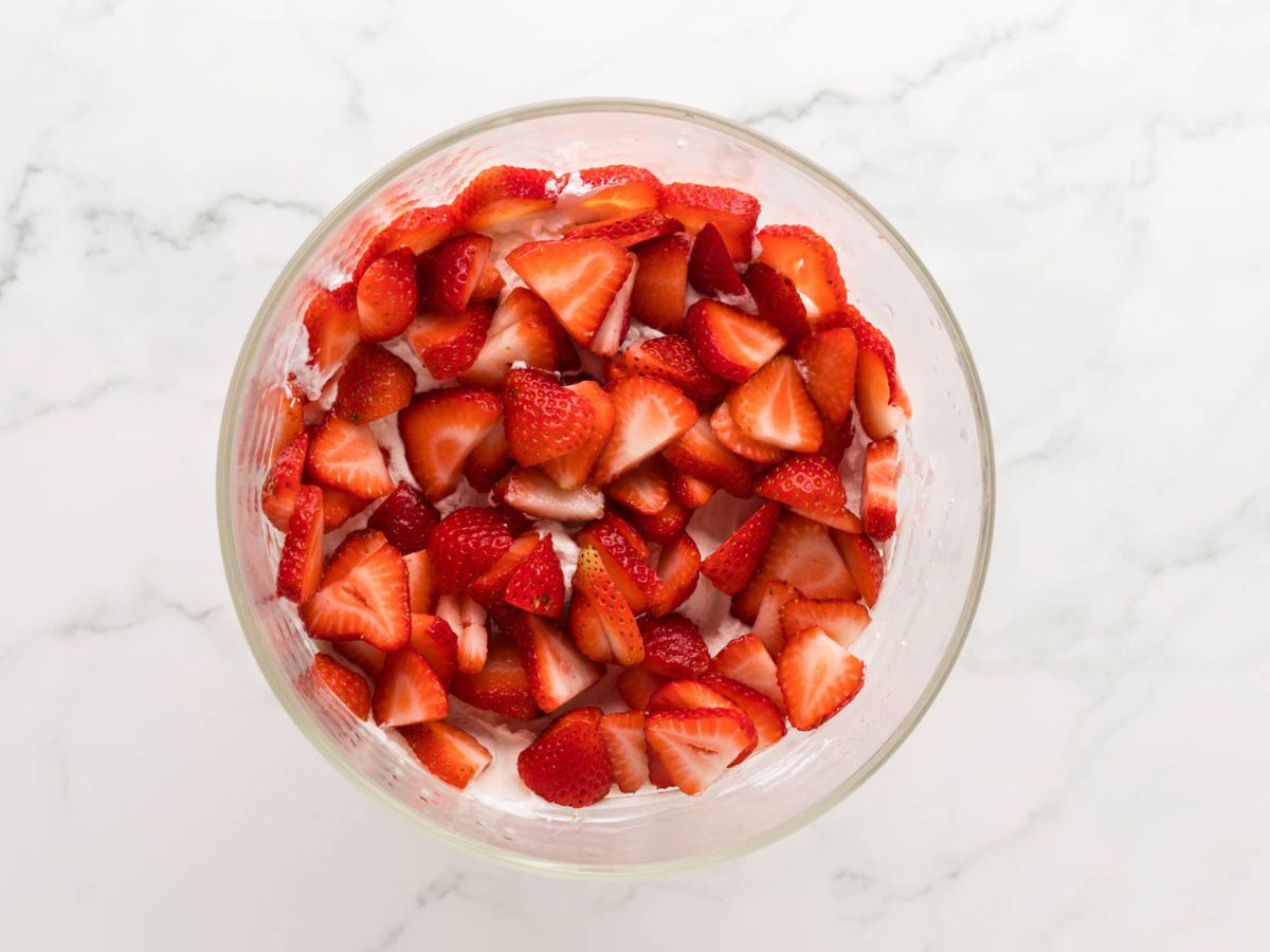 A layer of sliced strawberries on top of whipped cream.