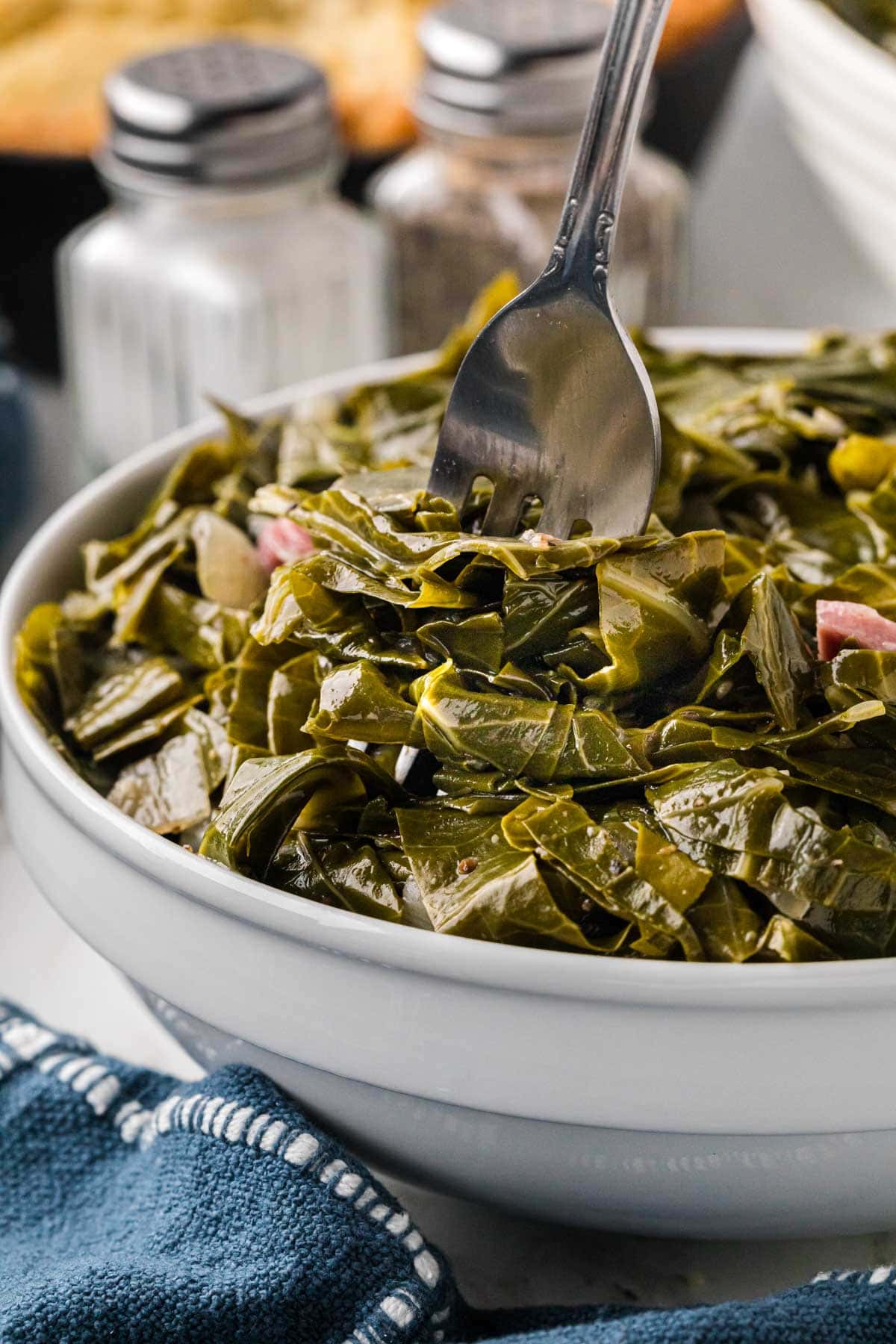 A fork taking a bite full of collard greens.