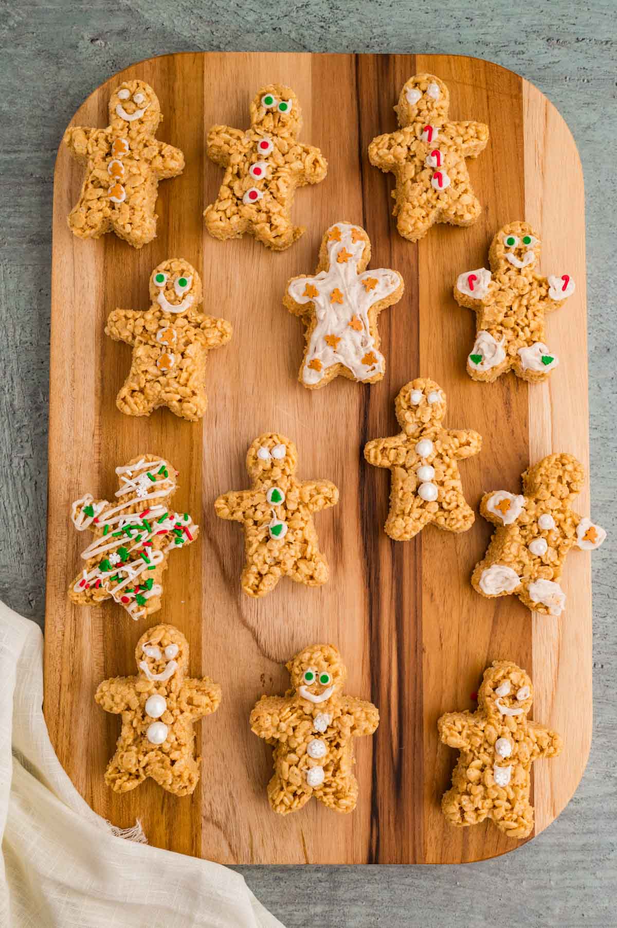 Rice krispie treats in the shape of gingerbread man on a wooden background.