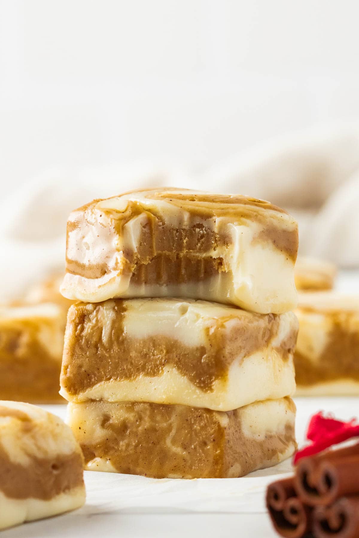 Stack of three pieces of gingerbread swirl fudge with the top one missing a bite.