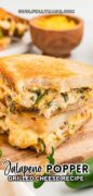 Jalapeno popper grilled cheese sandwich recipe is featured on a cutting board and revealing the cheesy insides.