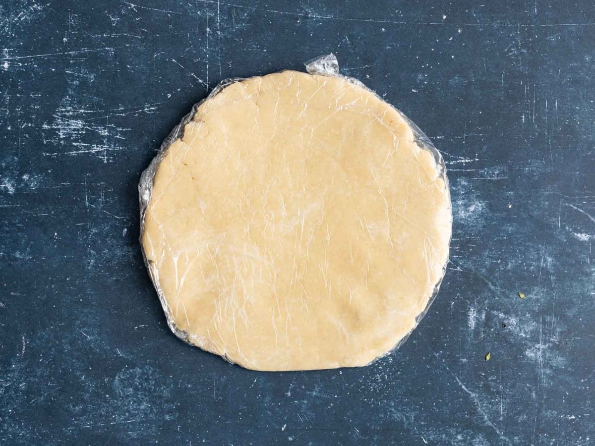 Pastry dough for the galette wrapped in plastic wrap.