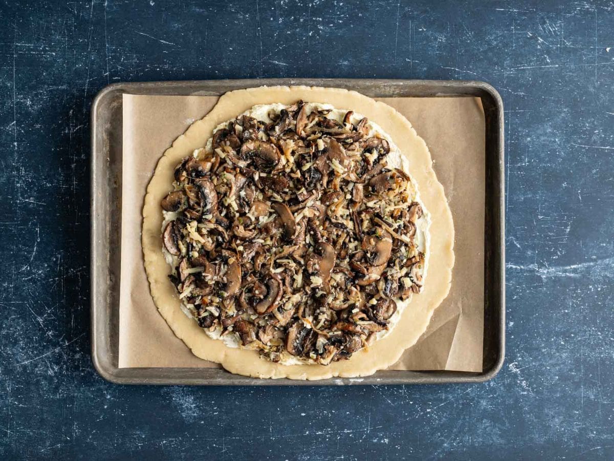 Mushroom mixture added on top of the cheese layer on the circle of pastry.