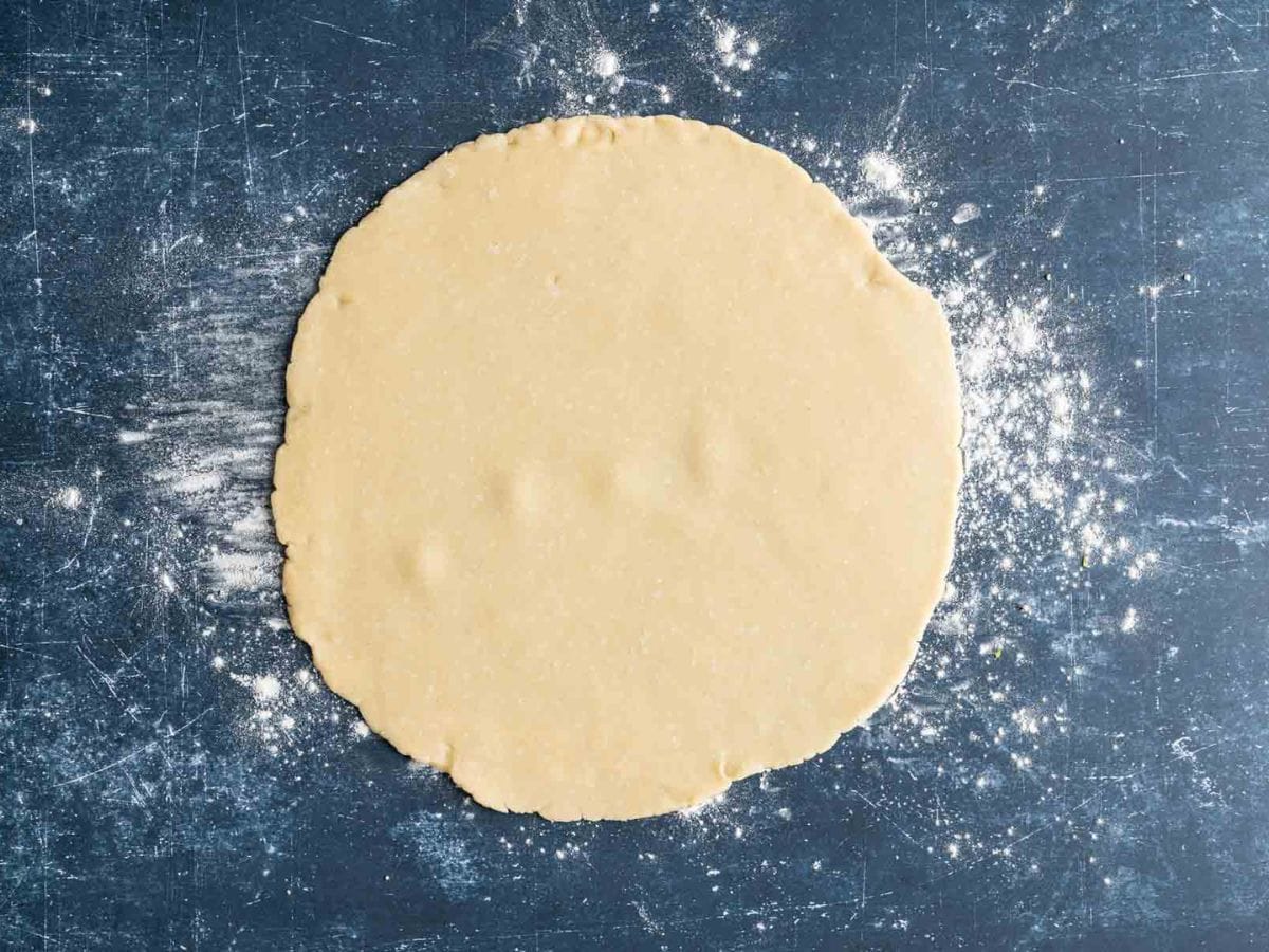 Rolled out pastry dough on a floured surface.