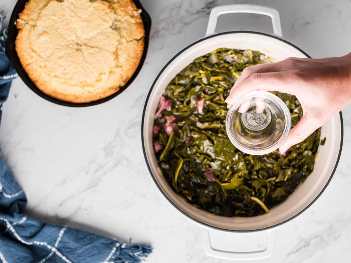 Adding vinegar to a pot a collards.