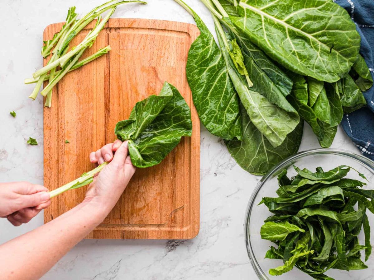 Removing the stem of the collard greens by hand.