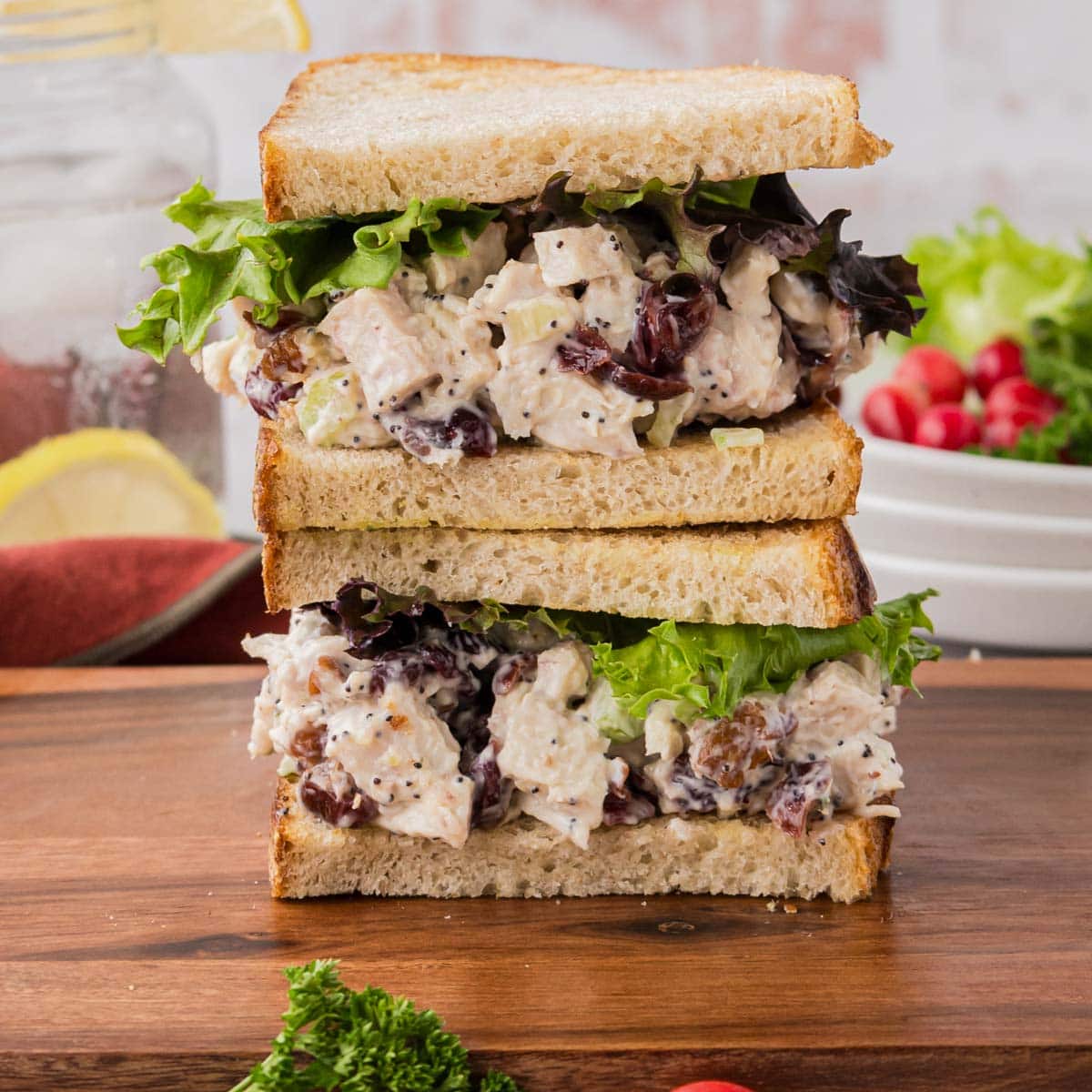 A turkey salad sandwich on italian bread cut in half and stacked on top of each other.