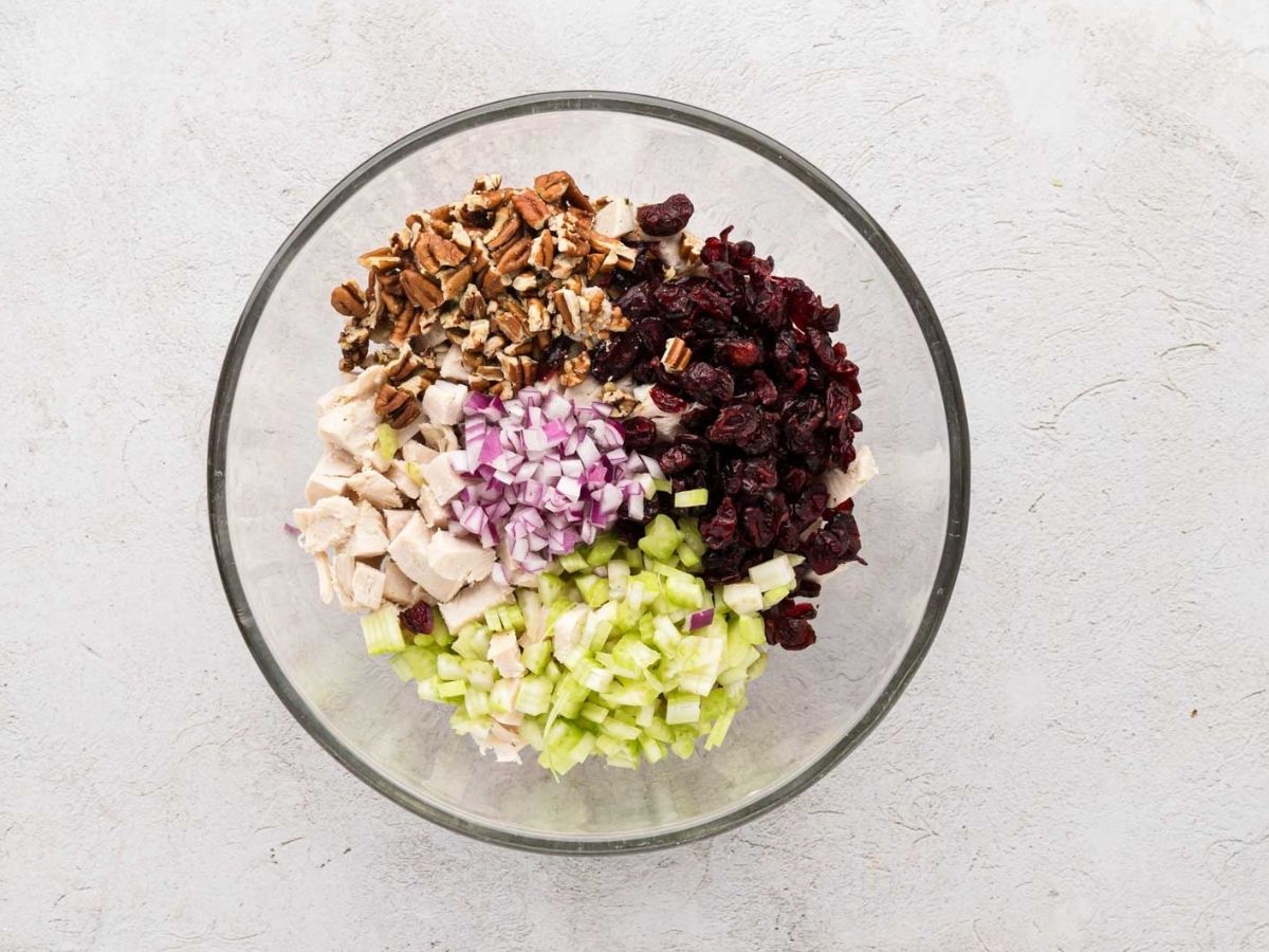 A clear bowl with all the ingredients for turkey salad.