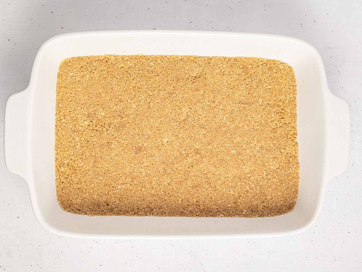 Graham cracker crust pressed into the bottom of a baking dish.