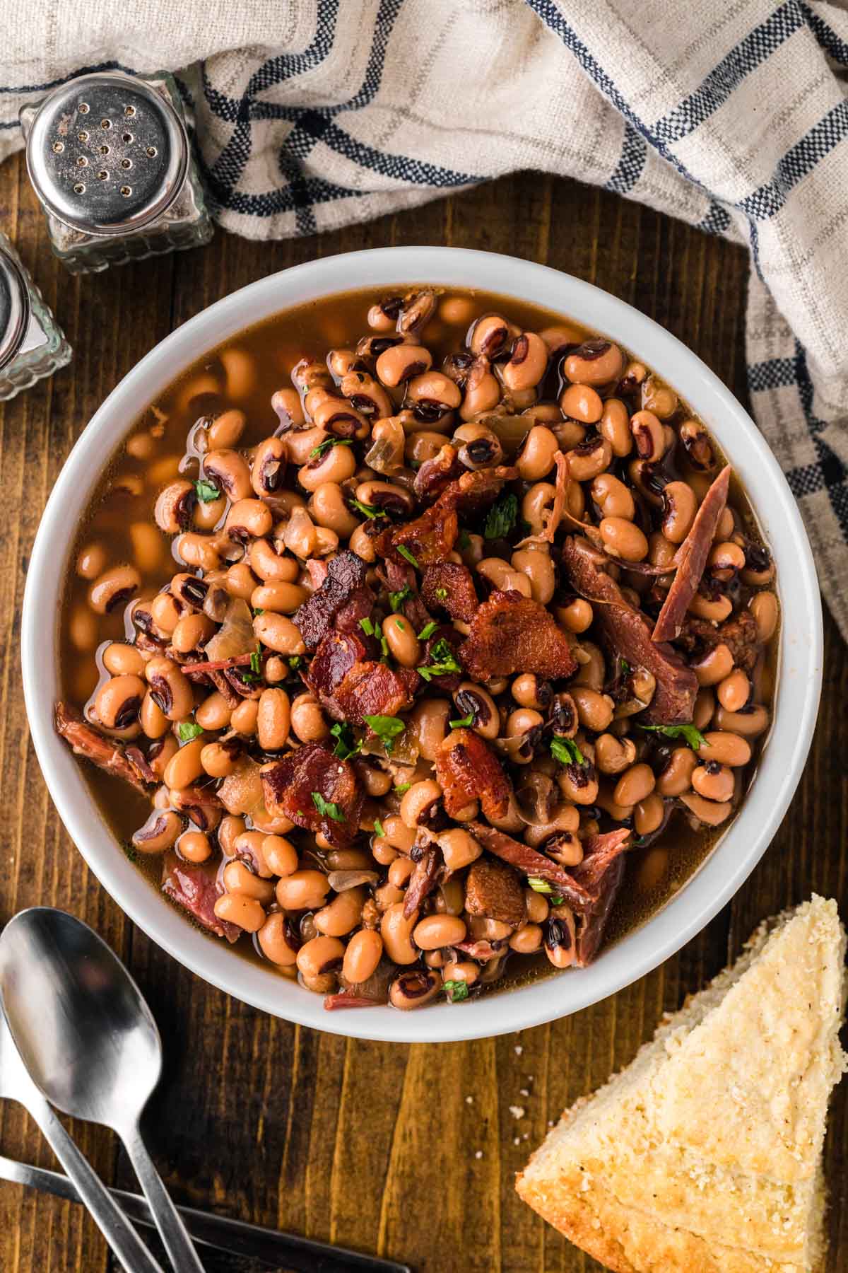 A white bowl with southern Black Eyed Peas cooked in the slow cooker.