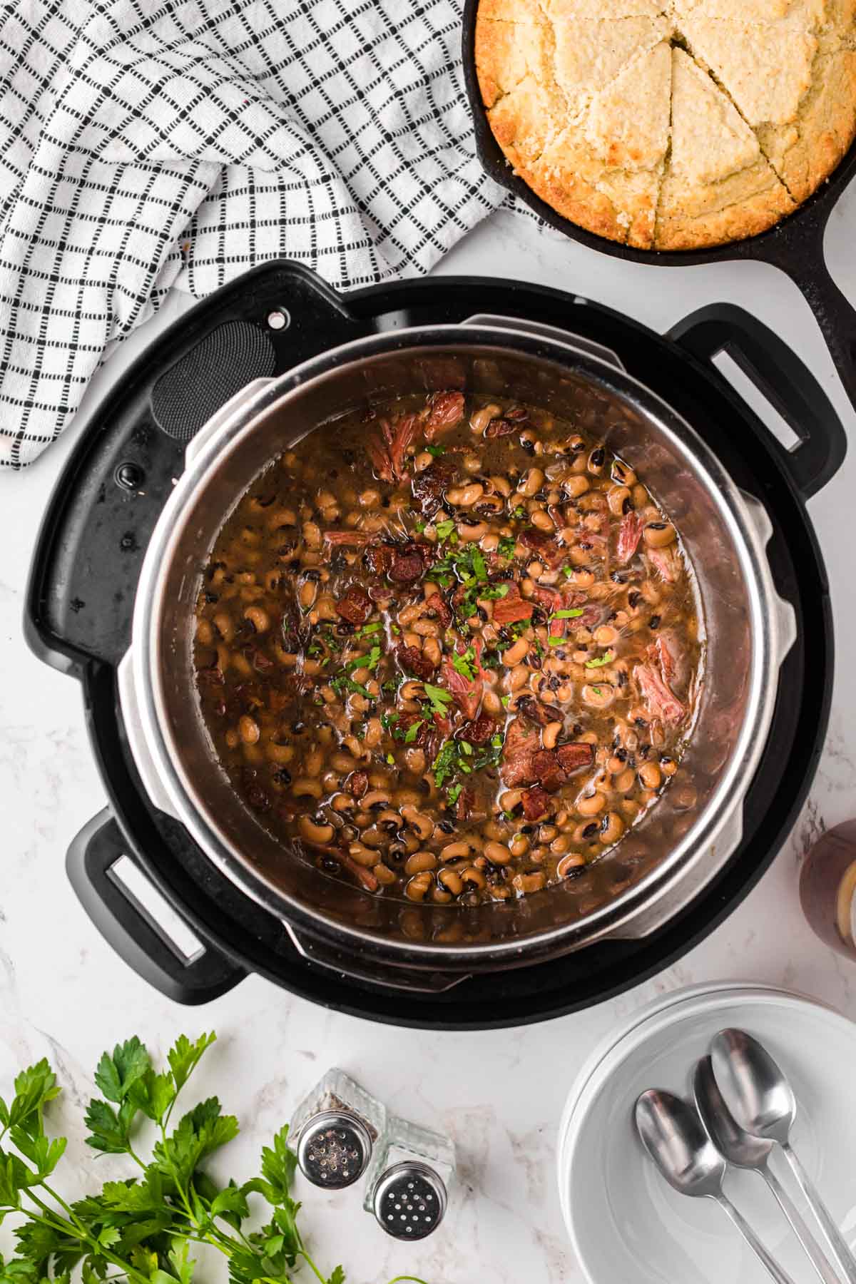 An instant pot with pressure cooked black-eyed peas, garnished with parsley.