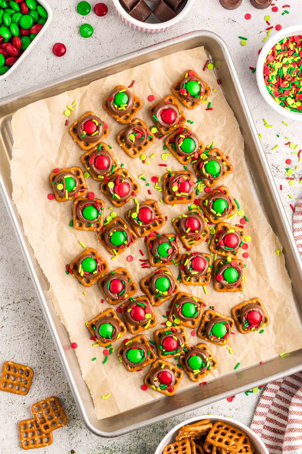 A baking tray line with parchment with Christmas Rolo pretzels.