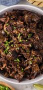 An oerhead shot of the shredded beef barbacoa in a white serving bowl.