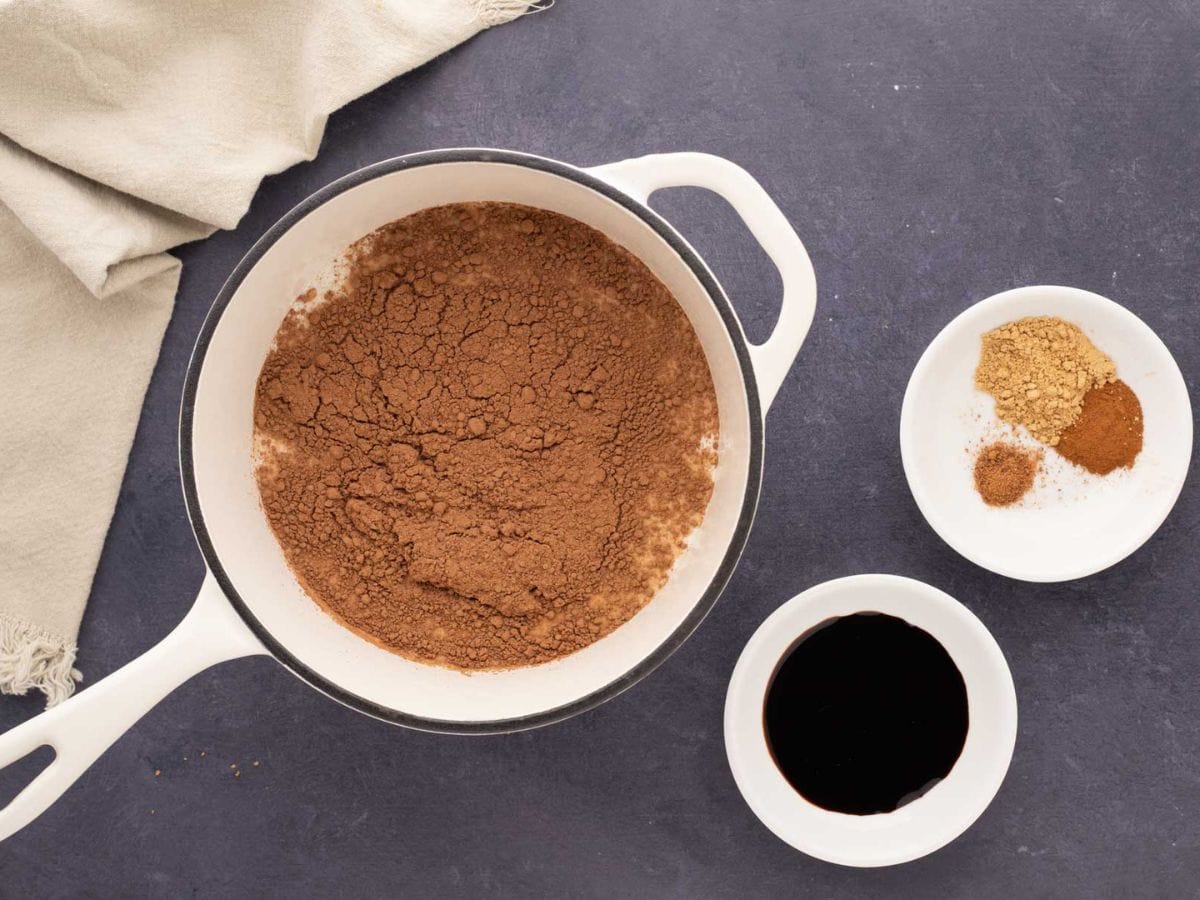 Hot cocoa ingredients added into a white pot.