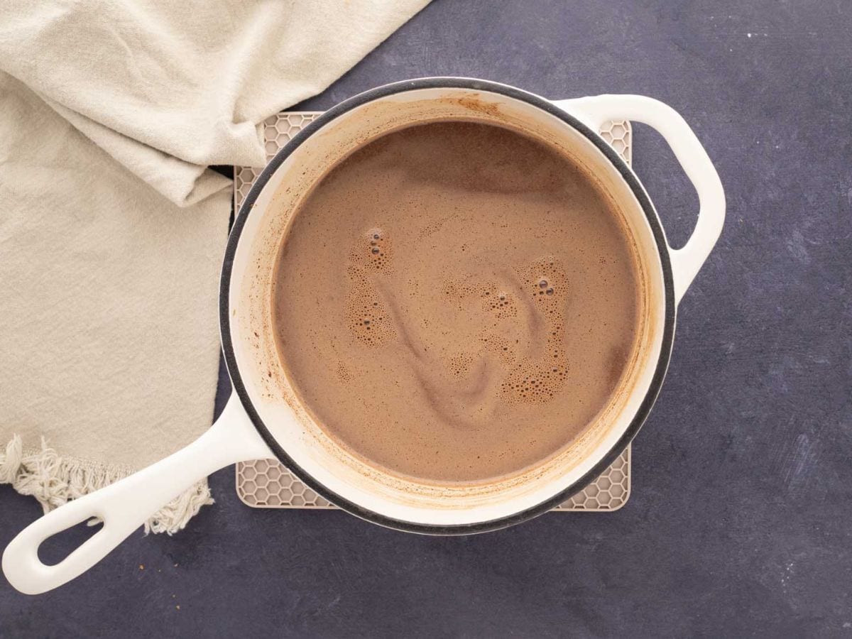 Gingerbread Hot Chocolate stirred until creamy in a white pot.