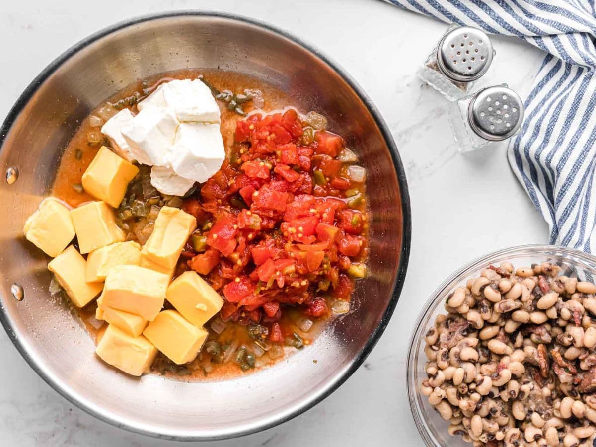 A skillet of sautéed veggies, cream cheese, Velveeta, and rotel.