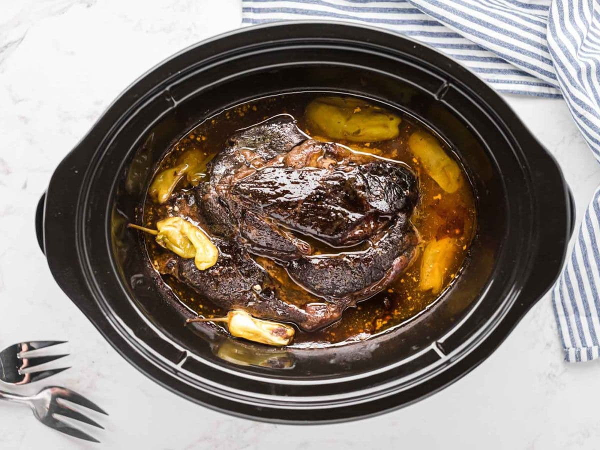 A whole cooked Mississippi pot roast in the slow cooker.