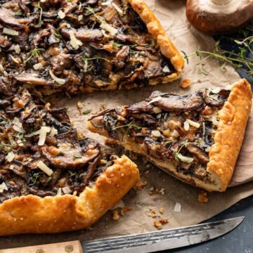 Slices of mushroom galette on a parchment paper with thyme garnishing them on top.