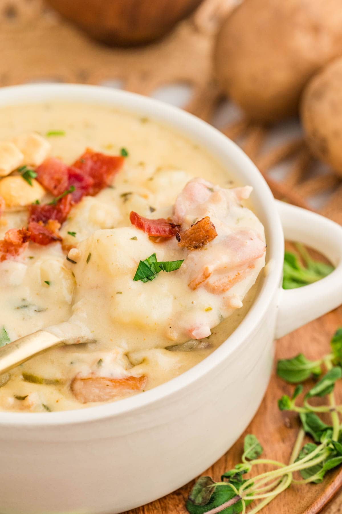 Spoon in a bowl of clam chowder picking up a bite.