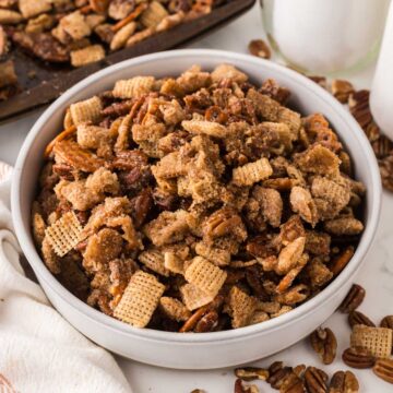 Large bowl of praline snack mix with a combination of pretzels, chex and pecans.