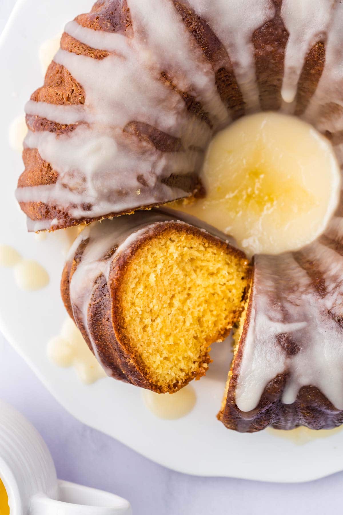 Rum bundt cake on a serving plate with one slice turned to the side to show the crumb.