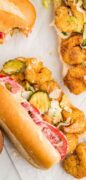 This is an image only picture os the Fried Shrimp Po Boy sandwich revealing the fried shrimp and other toppings spilling out.