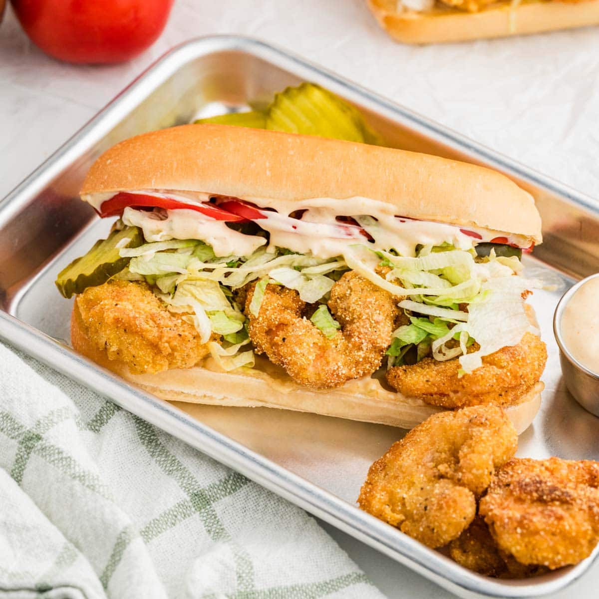 Shrimp po boy in a hoagie roll on a sheet pan.